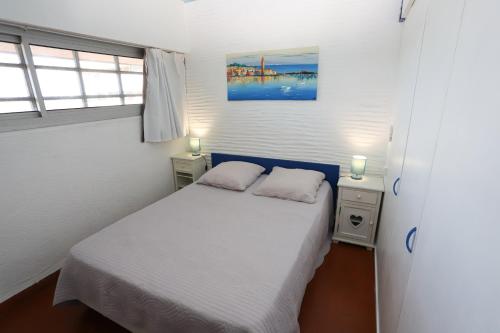 une petite chambre avec un lit et deux fenêtres dans l'établissement Magnifique vue mer Appart les pied dans l eau St Cyprien, à Saint-Cyprien