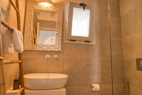 a bathroom with a sink and a mirror at Santa Maria Hotel in Elia Beach