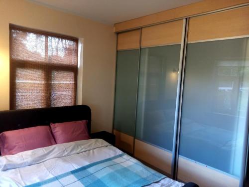 a bedroom with a bed and a glass closet at Apartment for 2 in the centre of town in Sigulda