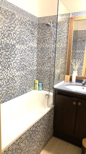 une salle de bain avec une baignoire et un lavabo dans l'établissement Bel appartement avec grande terrasse à 50m de la plage, à Cannes