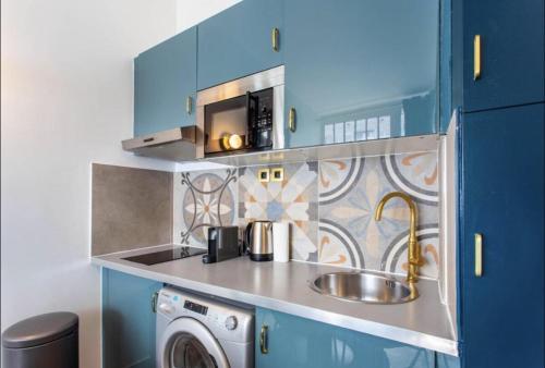 une cuisine avec un évier et une machine à laver dans l'établissement Charming 2BR # Grands Boulevards, à Paris