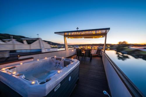 a hot tub on a deck next to the water at Floating house - ARIA in Pula