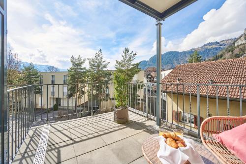 a balcony with a table and chairs on a balcony at Aparthotel Krone - Self Check-In in Interlaken