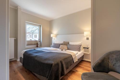 a bedroom with a bed and a window at Wittehuus Wohnung 6 in Borkum
