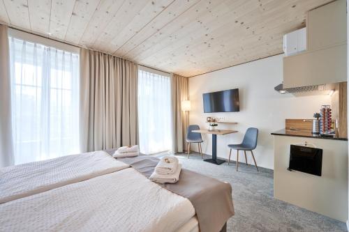 a hotel room with a bed and a table at Aparthotel Krone - Self Check-In in Interlaken