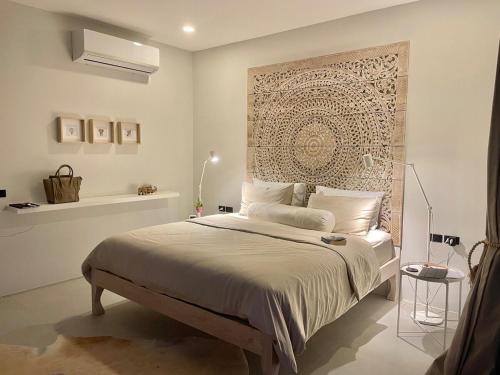 a bedroom with a bed with a large wall at Villa Miss Elephant in Ban Thung
