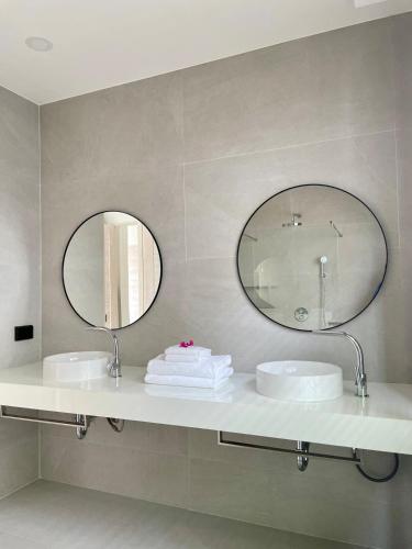 a bathroom with two sinks and two mirrors at Villa Miss Elephant in Ban Thung