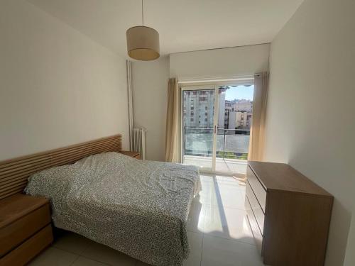 une chambre avec un lit et une fenêtre dans l'établissement Scaliero T2 avec terrasse plein soleil, à Nice