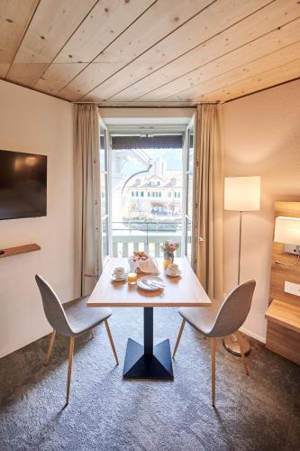 a dining room with a table and chairs and a window at Aparthotel Krone - Self Check-In in Interlaken