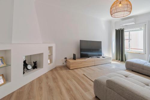 a living room with a flat screen tv and a couch at Lucia House - By Y Concept in Setúbal