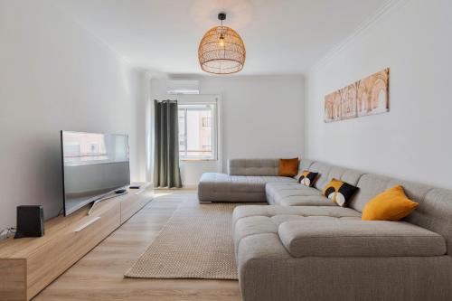 a living room with a couch and a flat screen tv at Lucia House - By Y Concept in Setúbal