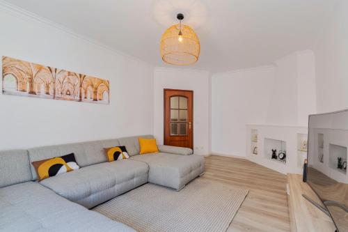 a living room with a couch and a tv at Lucia House - By Y Concept in Setúbal