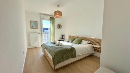 une chambre blanche avec un lit et une fenêtre dans l'établissement Henson, appartement pour 4 personnes, à Saint-Valery-sur-Somme