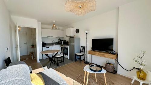 un salon avec un canapé et une cuisine dans l'établissement Henson, appartement pour 4 personnes, à Saint-Valery-sur-Somme