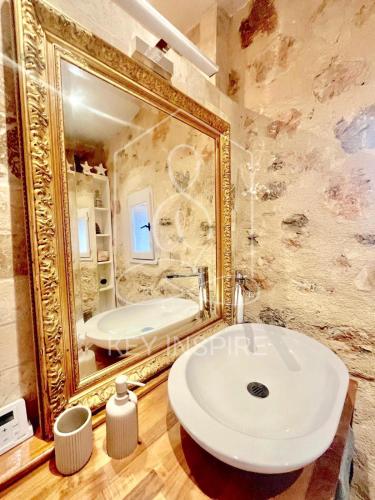 La salle de bains est pourvue d'un grand miroir et d'un lavabo blanc. dans l'établissement La Petite Maison d'Emmanuelle, à Le Tignet