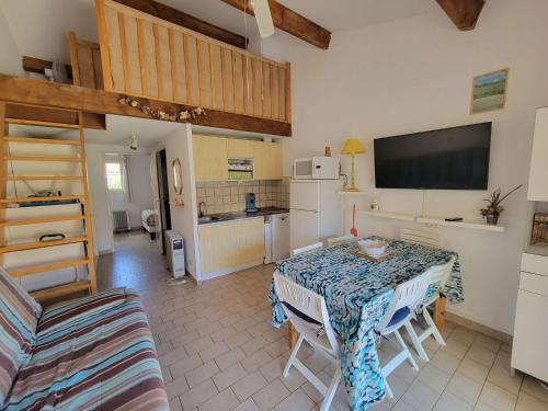 un salon avec une table et une cuisine dans l'établissement Maison de vacances, séjour cuisine, résidence MAS DE LA PLAGE 1, terrasse Sud dégagée 4 couchages Portiragnes LRMP77, à Portiragnes