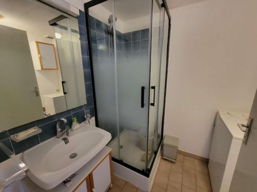 une salle de bain avec un lavabo et une douche en verre dans l'établissement Maison de vacances, séjour cuisine, résidence MAS DE LA PLAGE 1, terrasse Sud dégagée 4 couchages Portiragnes LRMP77, à Portiragnes