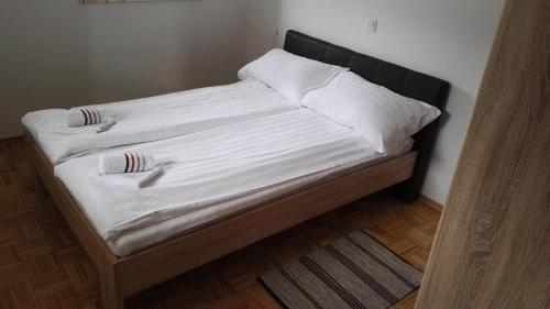 a bed with white sheets and pillows on it at Apartment Šija in Bohinj