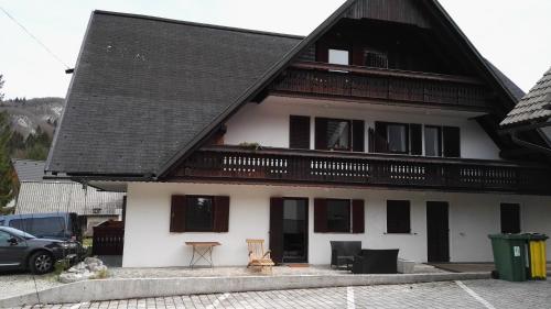 a white house with a black roof at Apartment Šija in Bohinj