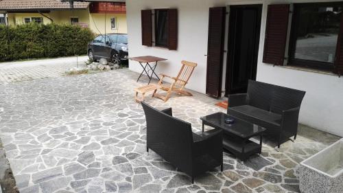 a patio with two chairs and a table and a table at Apartment Šija in Bohinj