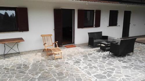 a patio with chairs and a table and a piano at Apartment Šija in Bohinj