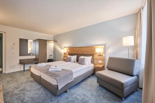 a hotel room with a bed and a chair at Aparthotel Krone - Self Check-In in Interlaken
