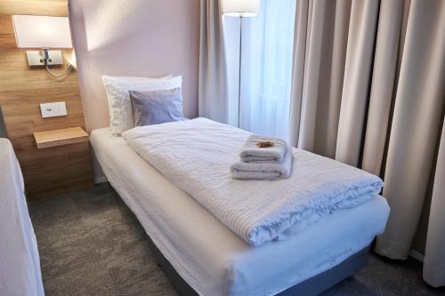 a small room with a bed with towels on it at Aparthotel Krone - Self Check-In in Interlaken