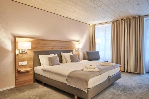 a bedroom with a large bed in a room at Aparthotel Krone - Self Check-In in Interlaken
