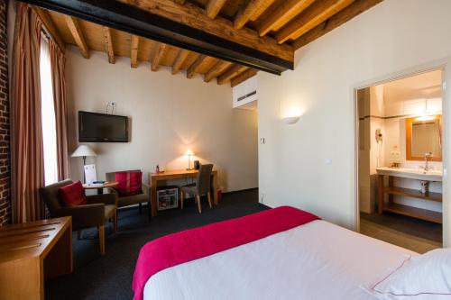 a hotel room with a bed and a desk and a bathroom at Ghent River Hotel in Ghent