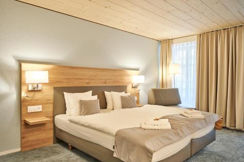 a bedroom with a large bed with two towels on it at Aparthotel Krone - Self Check-In in Interlaken