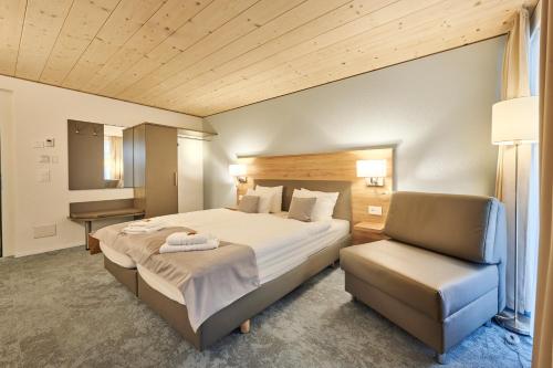 a hotel room with a bed and a chair at Aparthotel Krone - Self Check-In in Interlaken