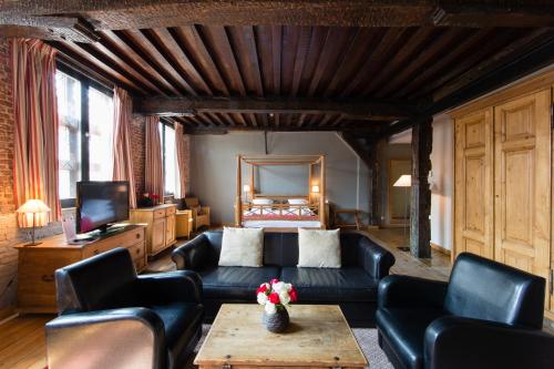 a living room with a couch and a television at Ghent River Hotel in Ghent