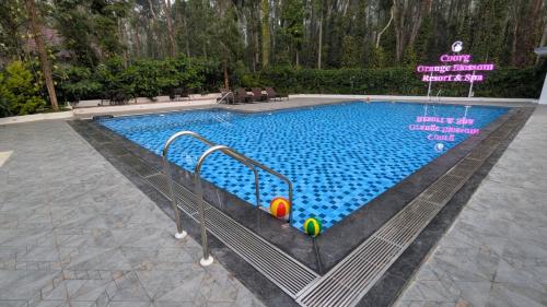 uma piscina com bolas no meio em Coorg Orange Blossom Resort and Spa em Suntikoppa