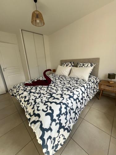 un lit avec un serpent rouge assis au-dessus dans l'établissement Charmant T2 rénové avec balcon, proche plage et commerces, à Arès