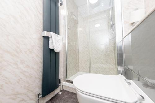a bathroom with a toilet and a glass shower at The Halfway House Inn in Leeds