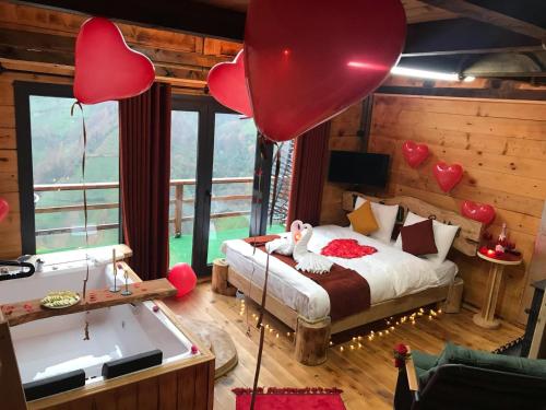 a bedroom with a bed and a tub with hearts on it at The Reo's Suit in Çayırdüzü