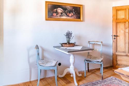 a table with two chairs and a painting on the wall at Landhaus Fröbel in Bad Liebenstein