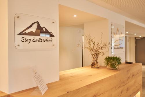 a sign for a shop on a wall in a room at Aparthotel Krone - Self Check-In in Interlaken