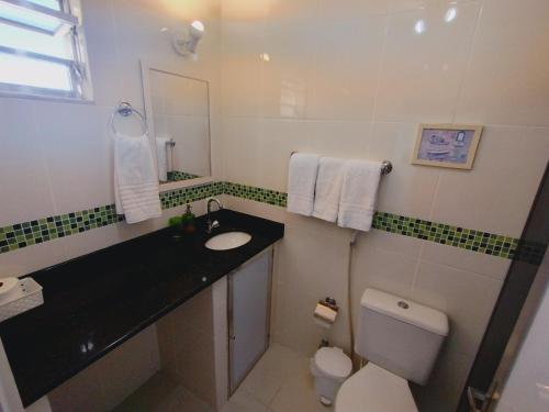 a bathroom with a black sink and a toilet at Refúgio Laguna in Araruama