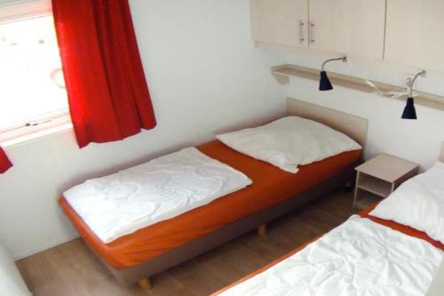 a small bedroom with two beds and a window at FRANKFURT - Haus am See mit Sandstrand & Seeblick nahe Rhein-Main und Spessart in Kahl am Main