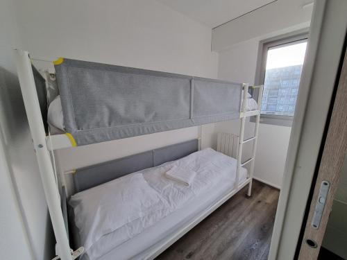 Ce lit superposé se trouve dans un dortoir doté d'une fenêtre. dans l'établissement Charmant Studio en bord de Mer, Piscine et Tennis, à Cabourg