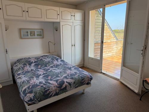 une chambre avec un lit et une grande fenêtre dans l'établissement La Corniche, à Agon-Coutainville