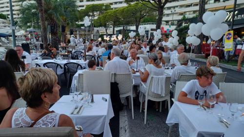 a group of people sitting at tables at a restaurant at Studio Etoile De Mer - Vue mer in Villeneuve-Loubet