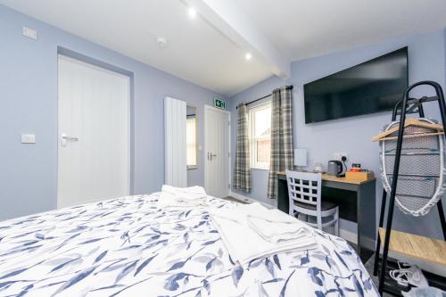 a bedroom with a large bed and a desk at The Halfway House Inn in Leeds