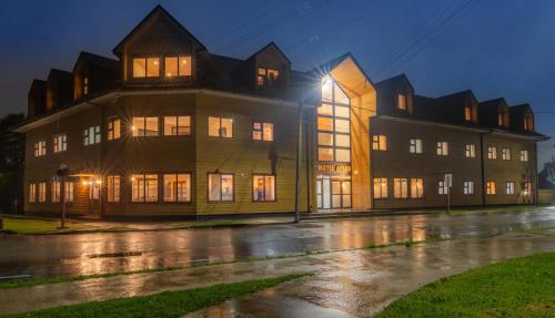 a large building on a rainy street at night at Gran Hotel Aysen in Puerto Aisén