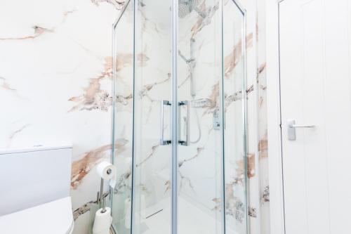 a shower with glass doors in a bathroom at The Halfway House Inn in Leeds