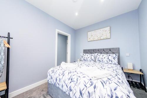a bedroom with a bed in a room with blue walls at The Halfway House Inn in Leeds