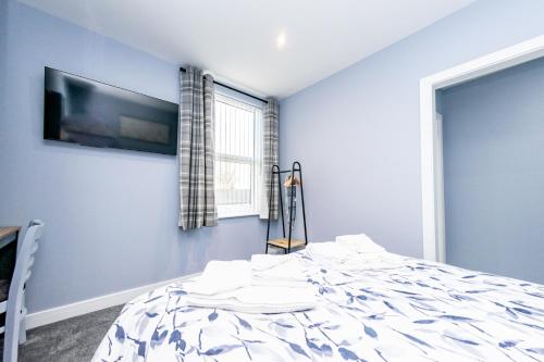 a bedroom with a bed and a tv on the wall at The Halfway House Inn in Leeds