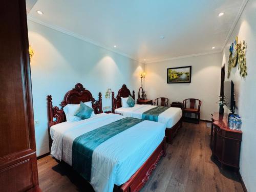 a hotel room with two beds and a television at Trường Giang Hotel 2 in Móng Cái