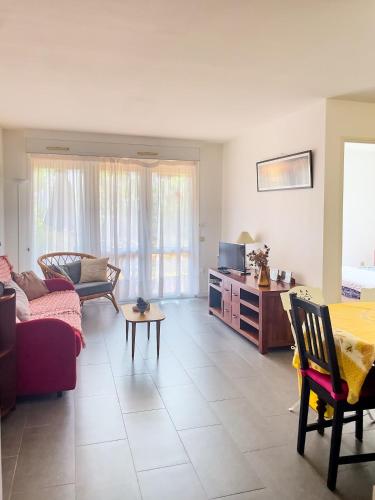 un salon avec un canapé et une table dans l'établissement Appartement avec terrasse près de la plage, à La Teste-de-Buch